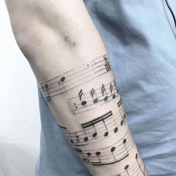 music notes tattoo on men sleeve