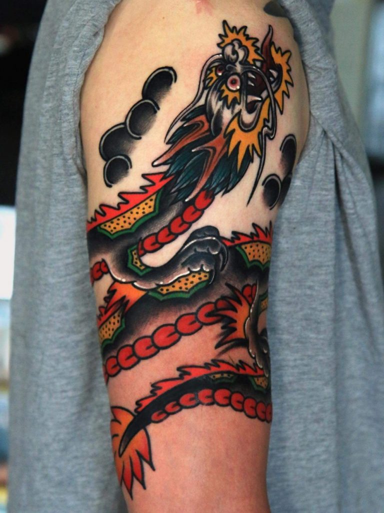 Dark color dragon arm tattoo