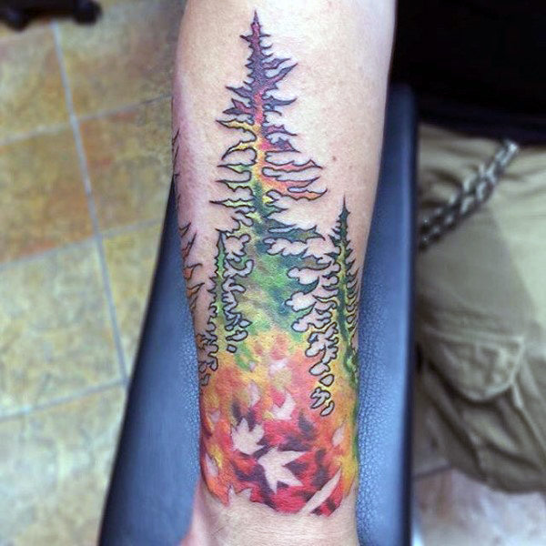 Abstract fall color forearm tattoo of forest on male