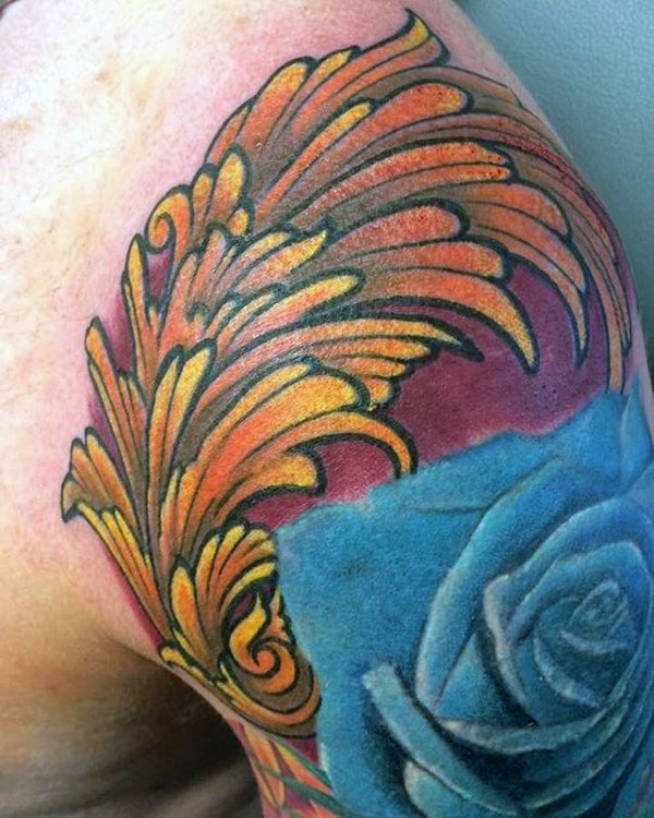 Awesome mens orange filigree tattoo with blue rose flower on upper arm and shoulder