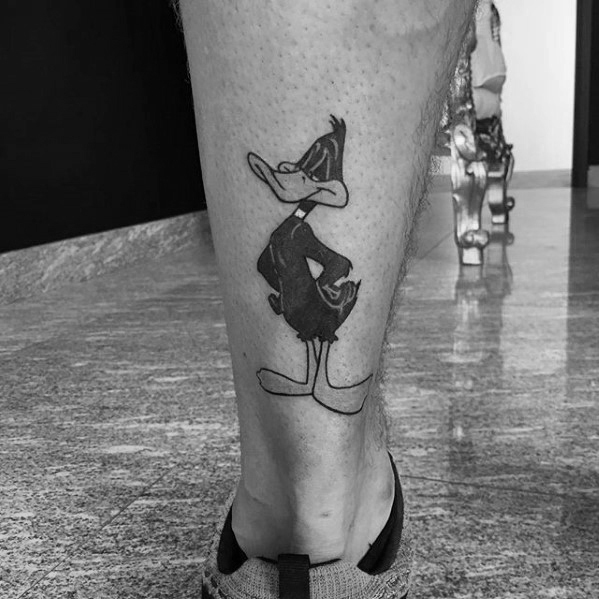 Back of leg daffy duck mens tattoo with looney tunes design Back of leg daffy duck mens tattoo with looney tunes design