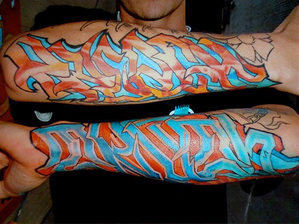 Blue and orange graffiti wildstyle lettering tattoo on forearm