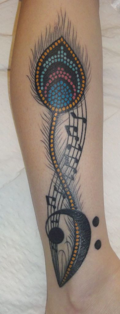 Feather and music tattoo