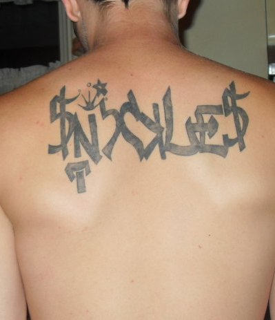 Grey ink graffiti tattoo on man upperback