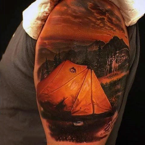 Guy with realistic tattoo of camping at night on bicep