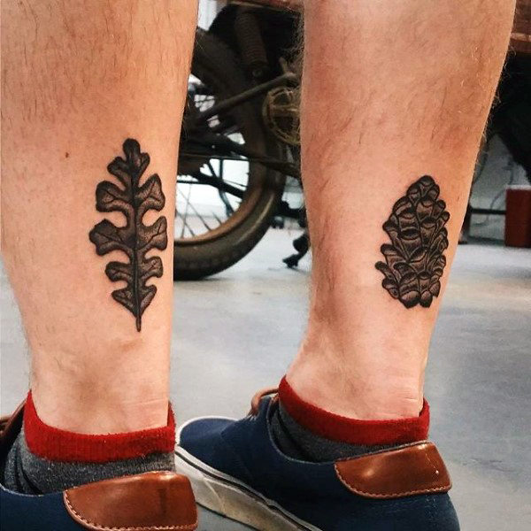 Males modern leaf and acorn tattoo on ankles