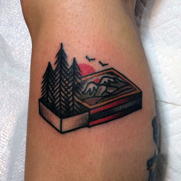Man with creative calf tattoo forest in matchbox