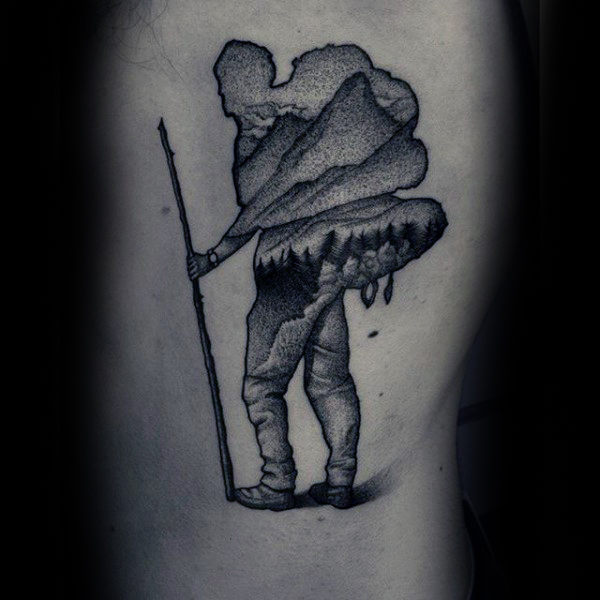 Man with large load on his back dotwork tattoo on forearms