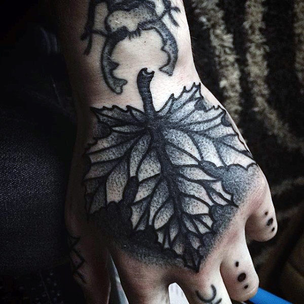Man with shaded autumn leaf hand tattoo in black ink