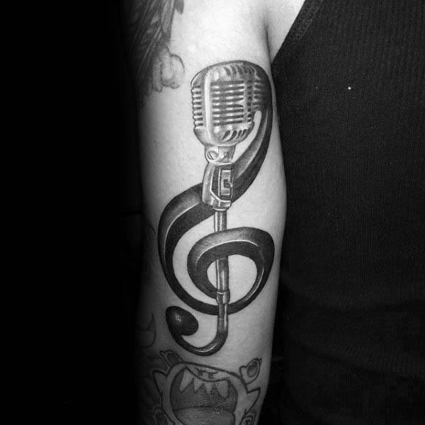 Microphone treble clef male back of arm tattoo