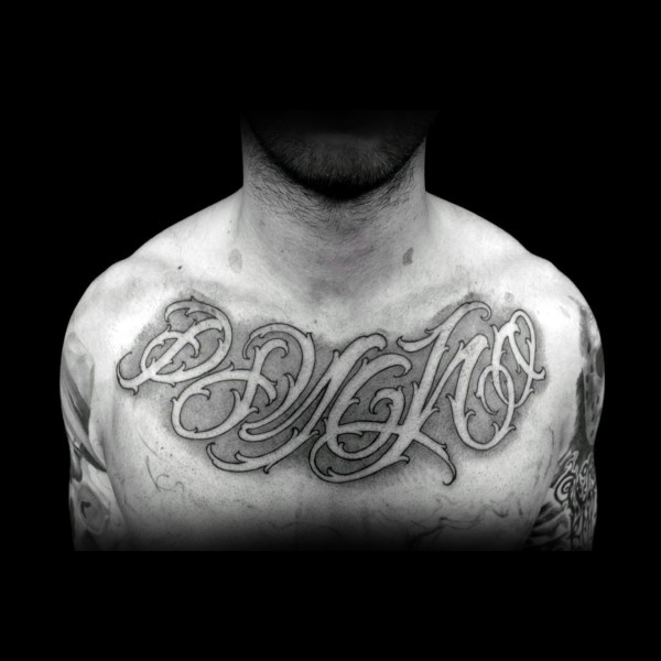 Shaded negative space male script chest tattoo