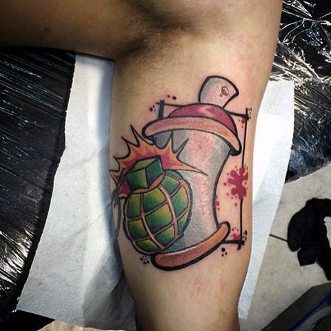 Spray paint can with grenade tattoo on bicep