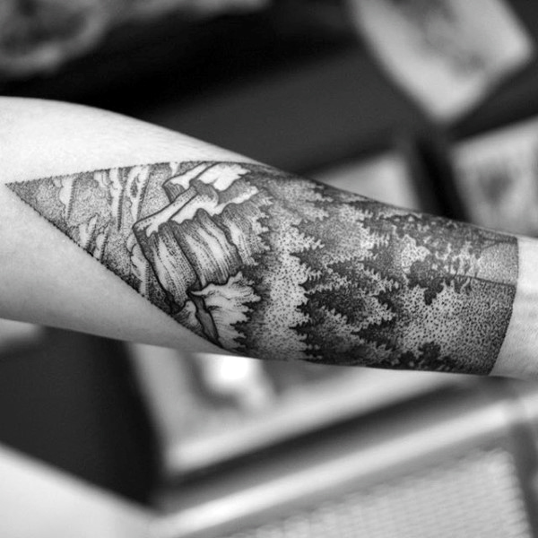 Stylist black ink forest and mountain tattoo half sleeve on man