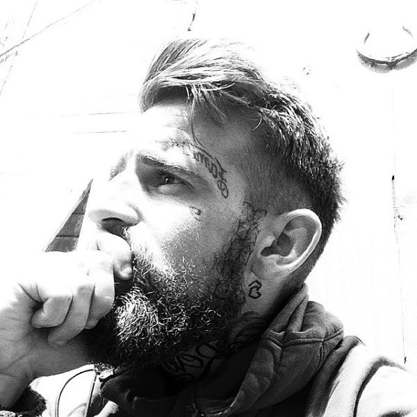 Male cursive lettering word face tattoo