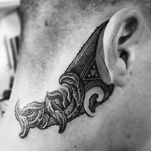 Man with tribal orante behind the ear tattoo