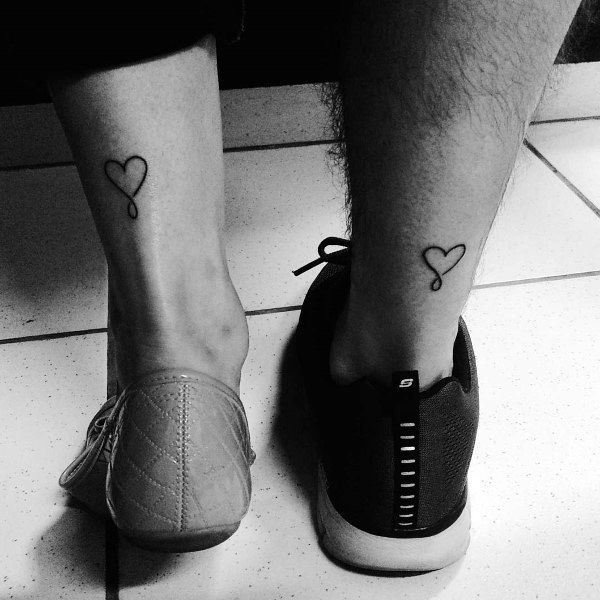 Married couple tattoos small design heart on back of lower legs