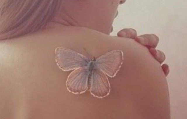 White butterfly tattoo on the shoulder