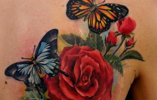 Butterfly Tattoo in green and yellow with a flower on top