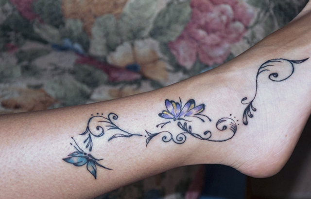 Simple and small butterfly Tattoo on the side of your ankle with a flower on foot