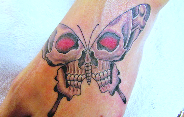 Skull Tattoo in a butterfly on foot