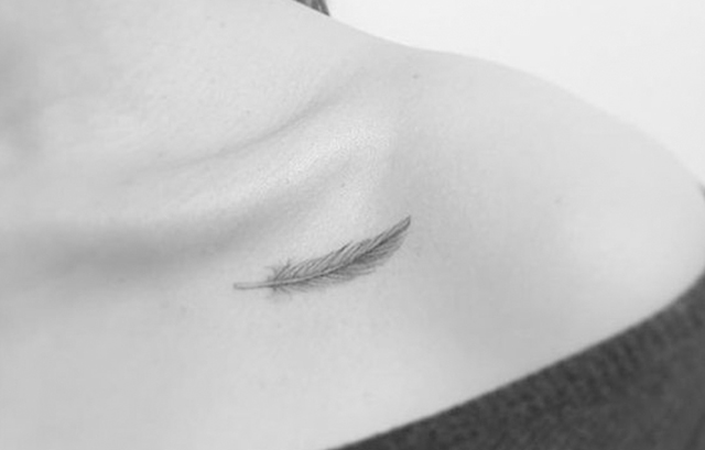 small feather tattoo on collarbone