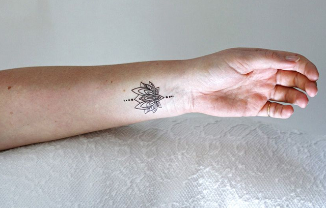 Tiny Lotus Tattoo on Her Wrist