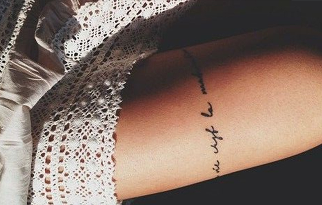 Tiny Quote Tattoo on Her Leg in Italics