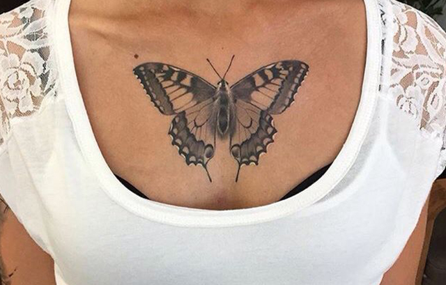 butterfly tattoo on chest going down the cleavage