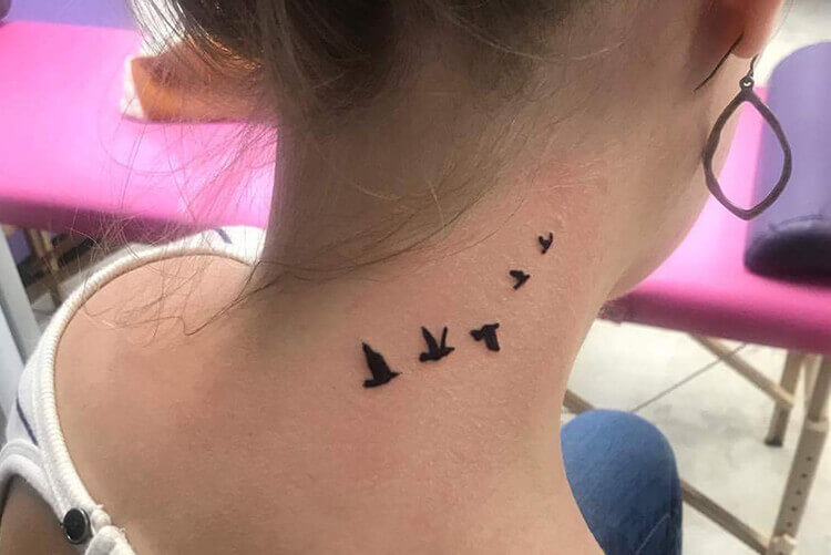 Tiny Flying Bird Tattoo on Neck