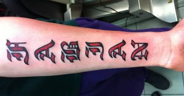 Red colored ambigram tattoo on forearm