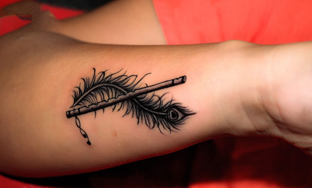 Peacock feather with a flute Tattoo