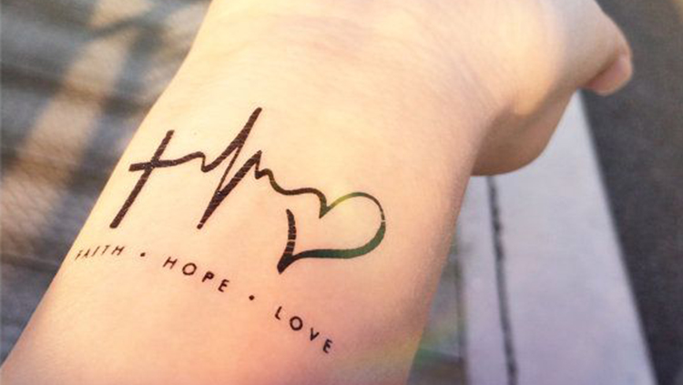 miniature heartbeat symbol tattoo on wrist