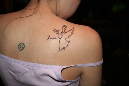 Miniature angel tattoo on shoulder blade