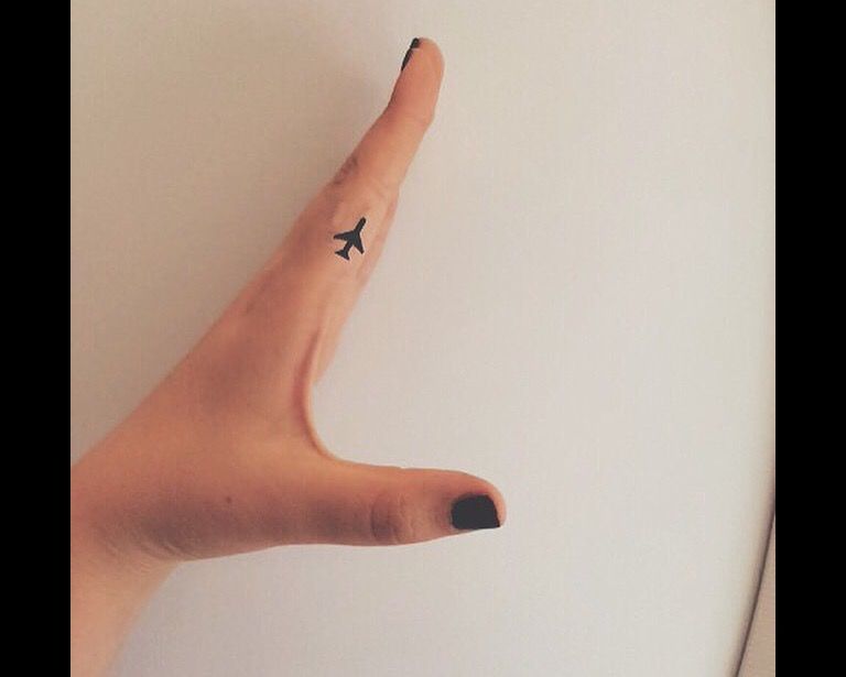 Tiny Airplane tattoo on finger