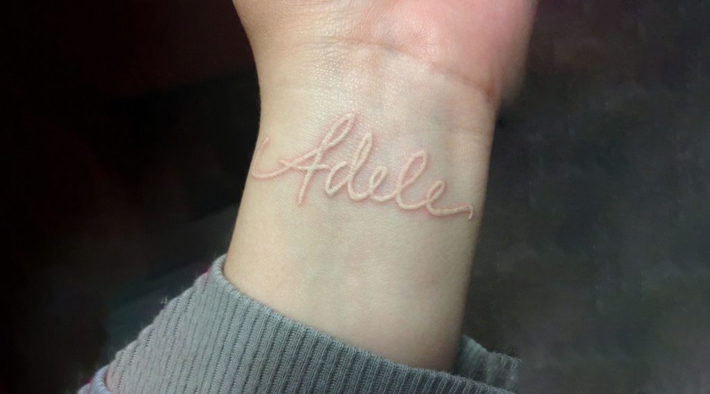 Name tattoo in white ink