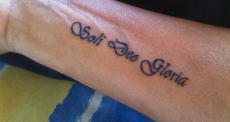 latin phrase ‘Soli Deo Glory’ on your hand