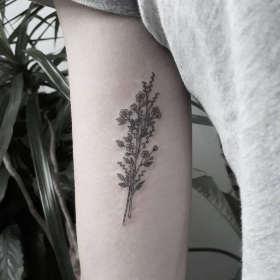 Minimalist floral bouquet tattoo on upper arm