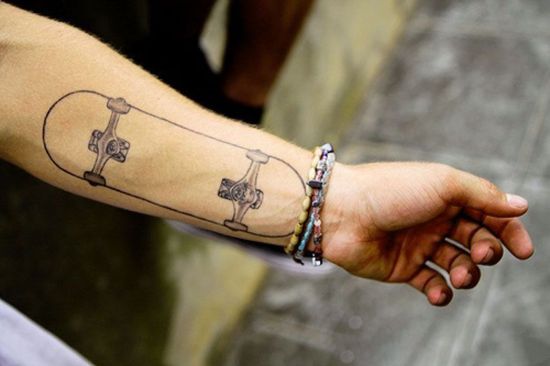 Skateboard tattoo on boys arm