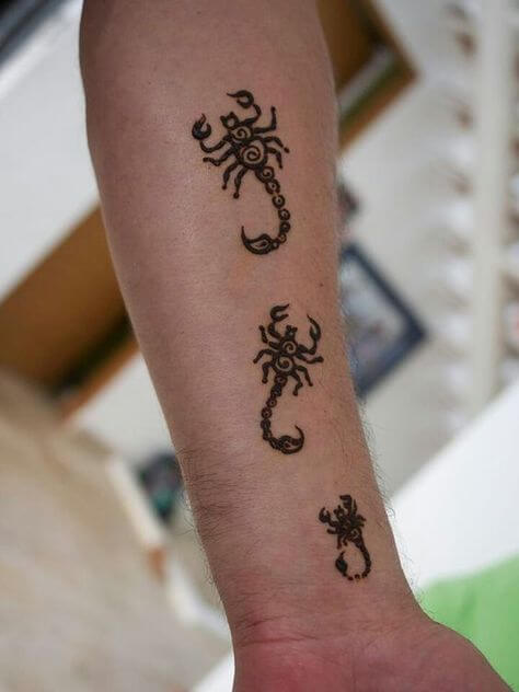 Three Scorpio tattoo designs on arm