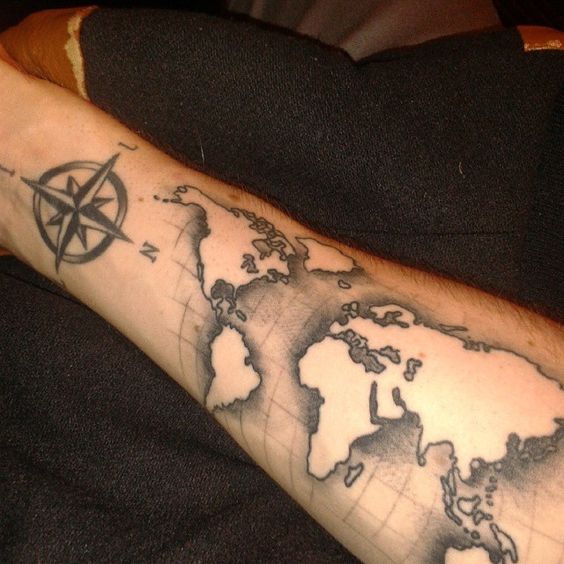 World map tattoo with compass on arm