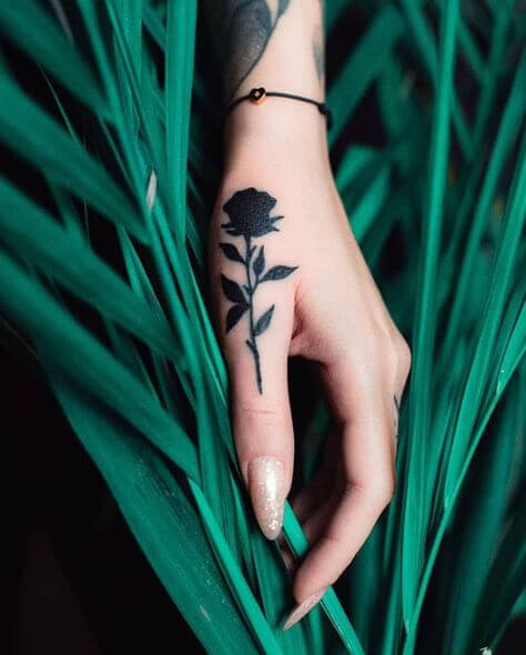 tiny rose tattoo on thumb