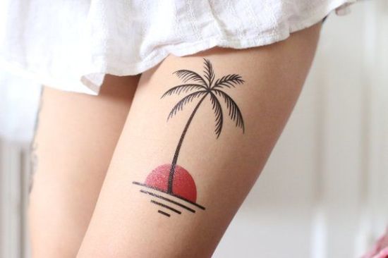 Palm with sun tattoos on girls thigh