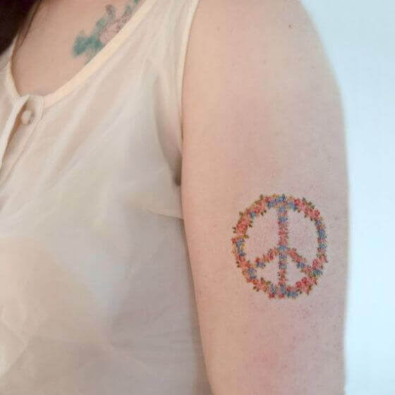 Floral peace sign tattoo for women