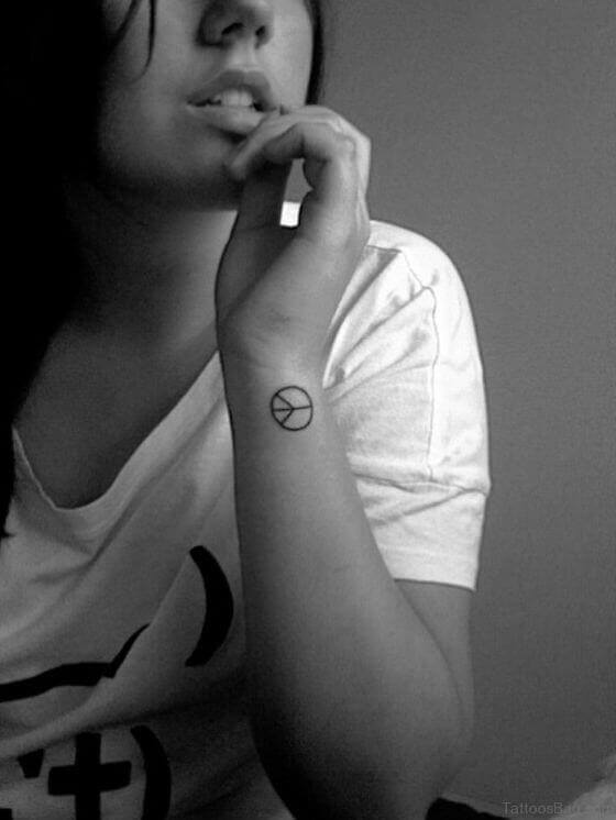 Small peace sign tattoo on Wrist