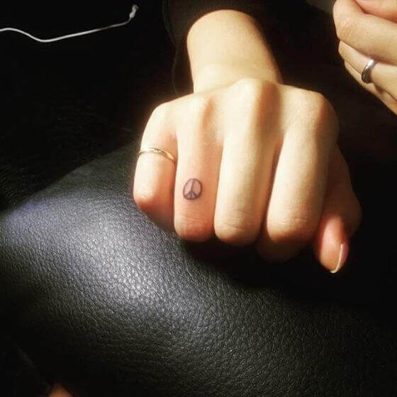 Tiny peace tattoo on finger
