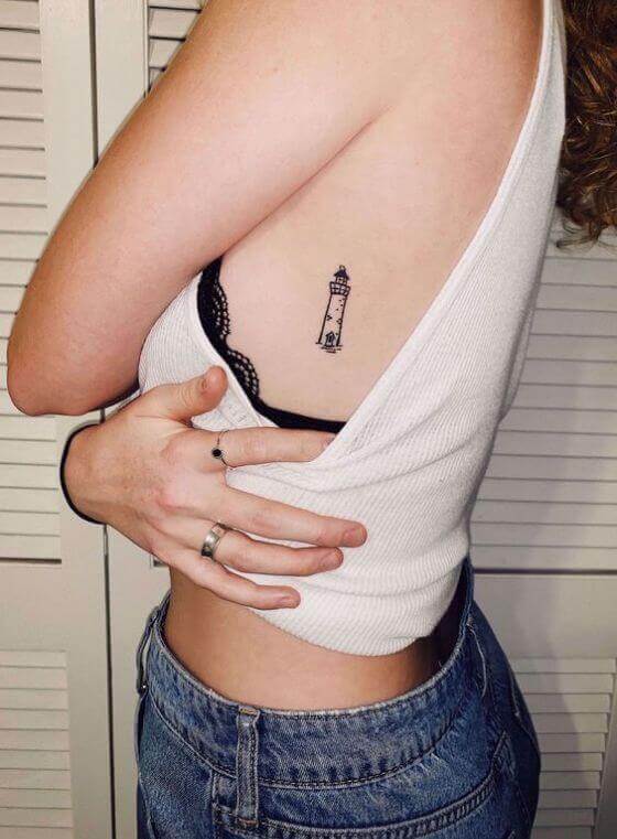tiny lighthouse tattoo on women ribcage