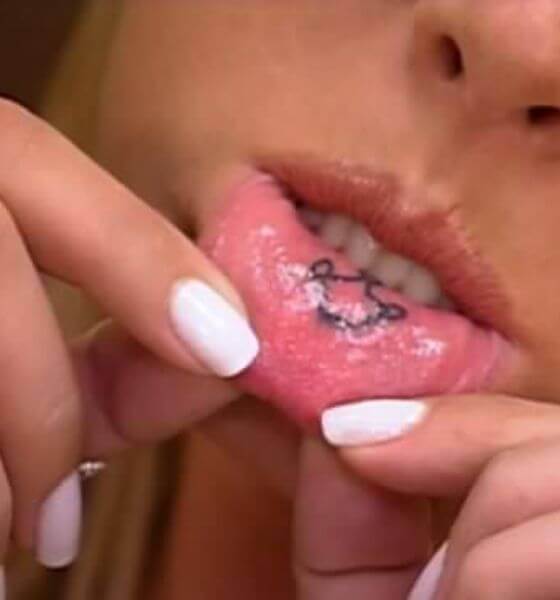 A Crown etched on inner lips tattoos