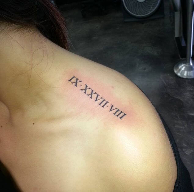 Top of the shoulder tattoo of a date in roman numerals