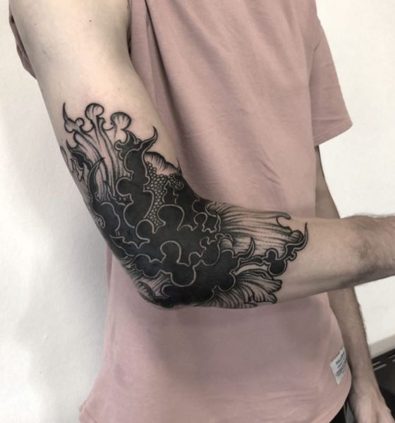 Black ink tattoo on elbow for men