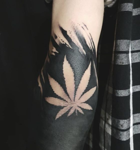 Dark leaf tattoo on elbow